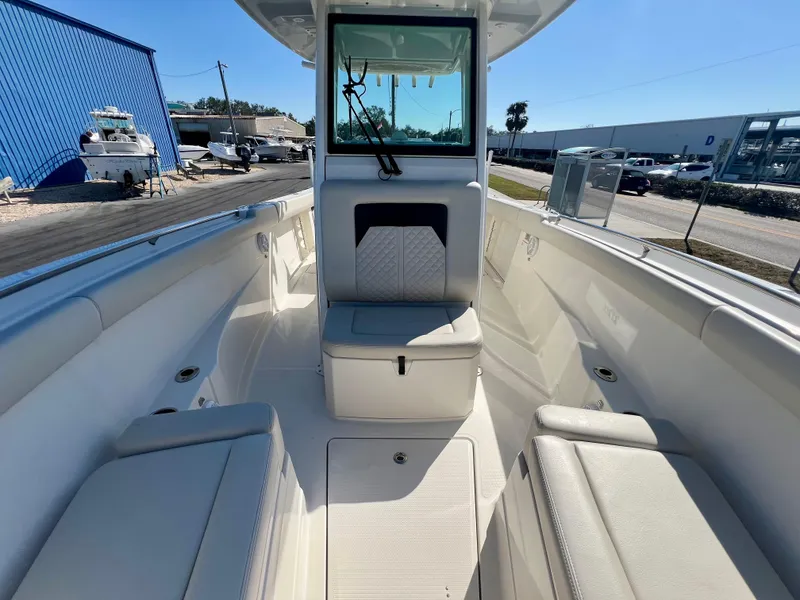 Slide: The Image of 2023 Sailfish 272 CC boat interior with seating and storage, docked outdoors. - 31
