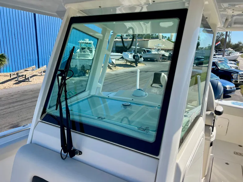 Slide: The Image of 2023 Sailfish 272 CC boat windshield with wipers, docked near blue building. - 35