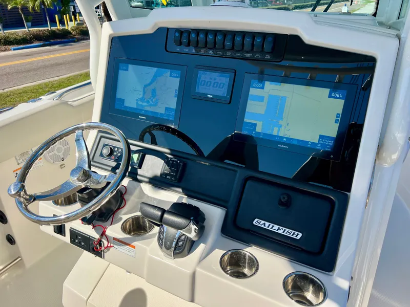 Slide: The Image of 2023 Sailfish 272 CC boat dashboard with dual navigation screens and steering wheel. - 7