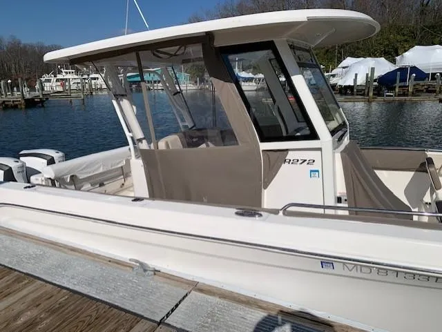 Slide: The Image of 2019 Robalo R272 Center Console boat docked at a marina. - 1