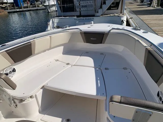 Slide: The Image of 2019 Robalo R272 Center Console boat interior with spacious seating at a marina. - 13