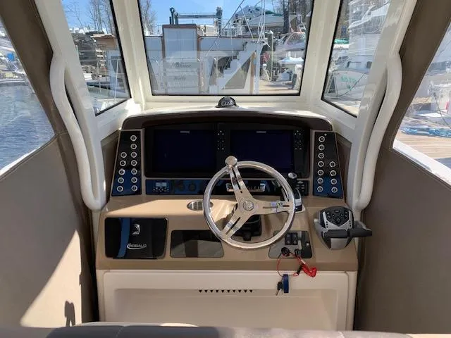 Slide: The Image of 2019 Robalo R272 Center Console helm with dual displays and steering wheel. - 14