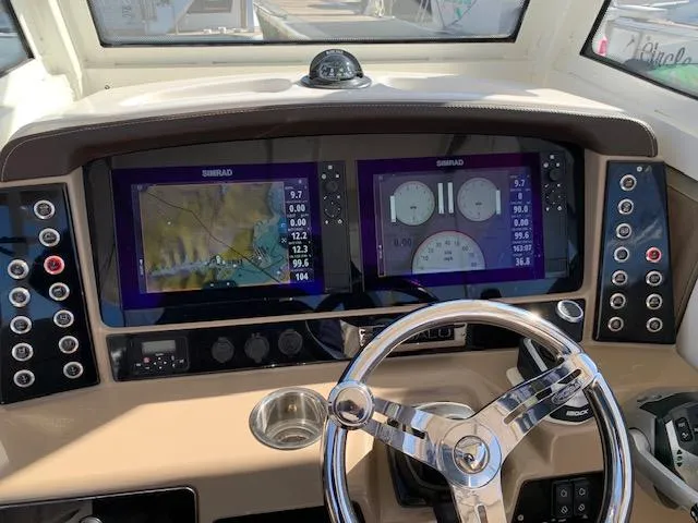 Slide: The Image of 2019 Robalo R272 Center Console dashboard with dual Simrad displays and steering wheel. - 18