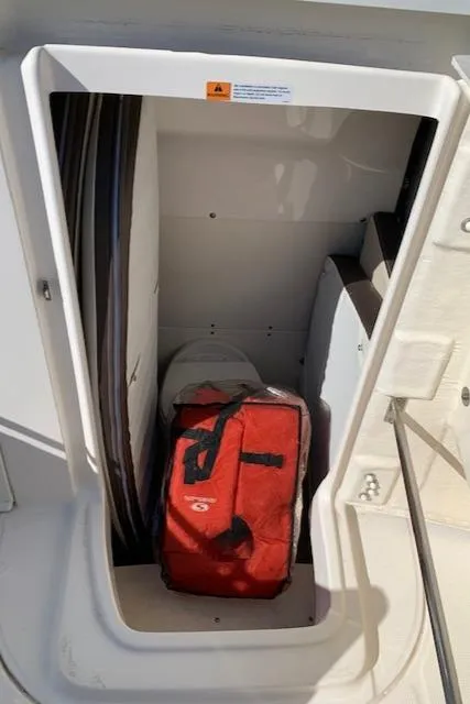 Slide: The Image of 2019 Robalo R272 Center Console storage compartment with red bag inside. - 27