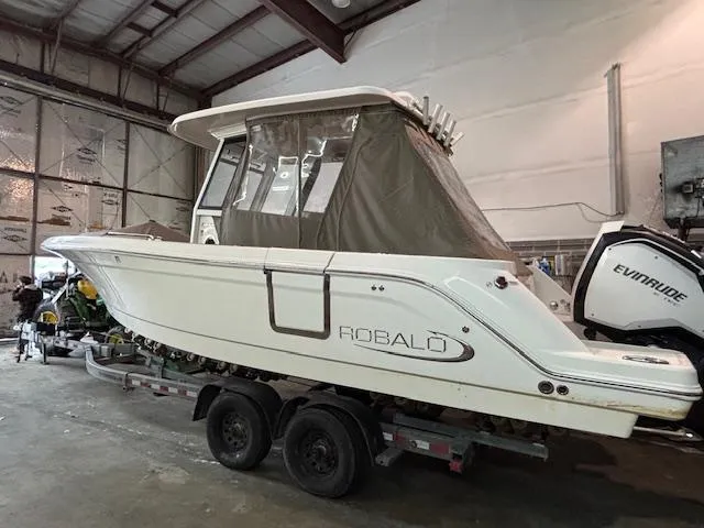 Slide: The Image of 2019 Robalo R272 Center Console boat on trailer in indoor storage. - 30
