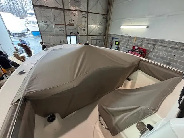 Slide: The Image of 2019 Robalo R272 Center Console boat with protective cover in a garage setting. - 36