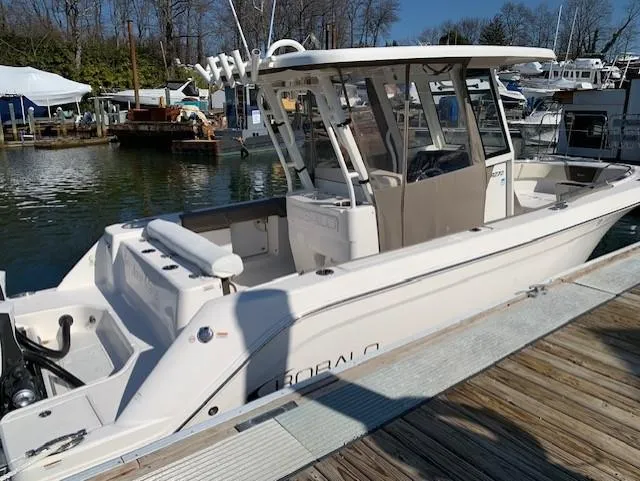 Slide: The Image of 2019 Robalo R272 Center Console boat docked at a marina. - 4
