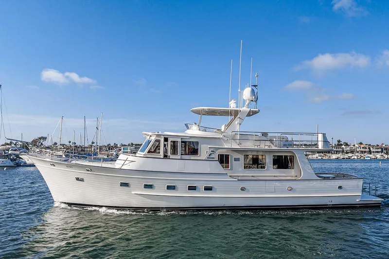 Slide: The Image of 2018 Fleming 58 Pilothouse yacht cruising in a sunny marina. - 12