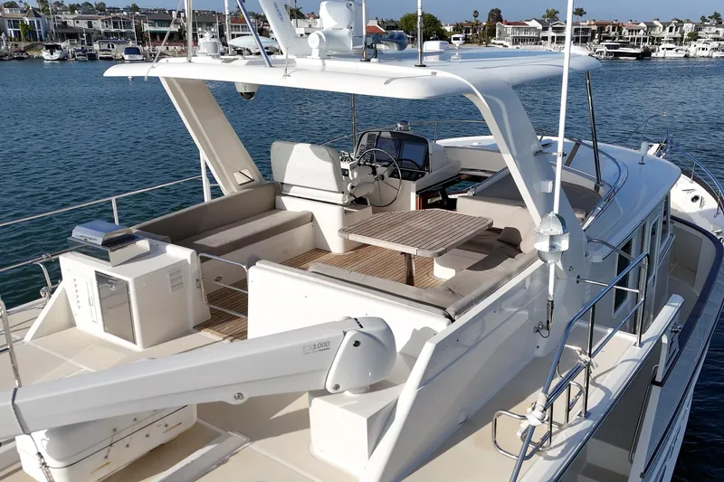 Slide: The Image of 2018 Fleming 58 Pilothouse yacht with spacious deck and modern amenities, docked in a marina. - 18
