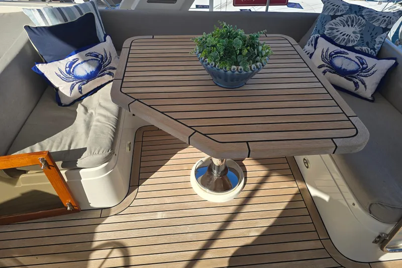 Slide: The Image of Cozy seating area on 2018 Fleming 58 Pilothouse with nautical-themed cushions and wooden table. - 27