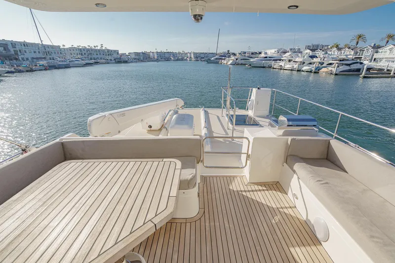Slide: The Image of 2018 Fleming 58 Pilothouse yacht deck with seating, table, and marina view. - 30