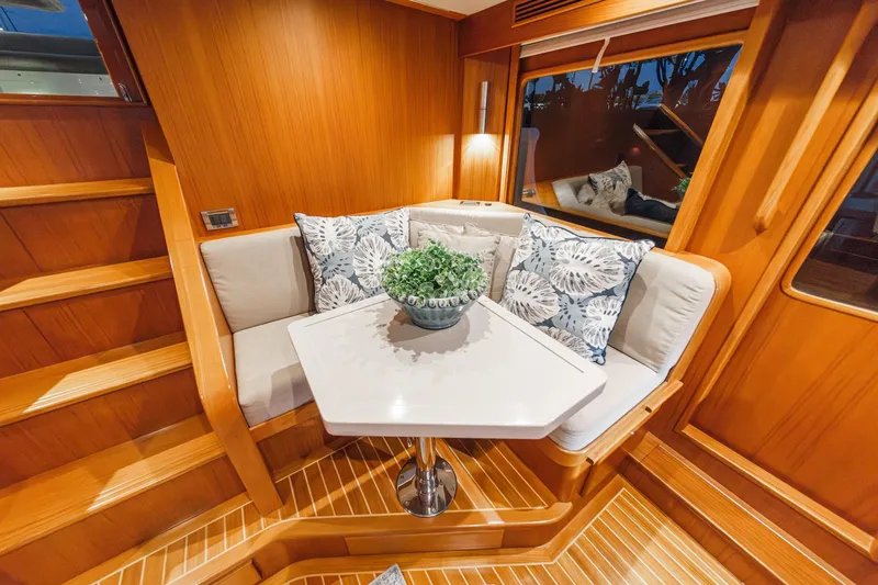 Slide: The Image of Cozy dining nook on 2018 Fleming 58 Pilothouse yacht with wooden interior and decorative pillows. - 44