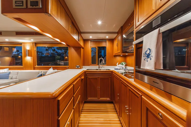 Slide: The Image of Luxurious kitchen interior of 2018 Fleming 58 Pilothouse yacht with wooden cabinetry and modern appliances. - 51