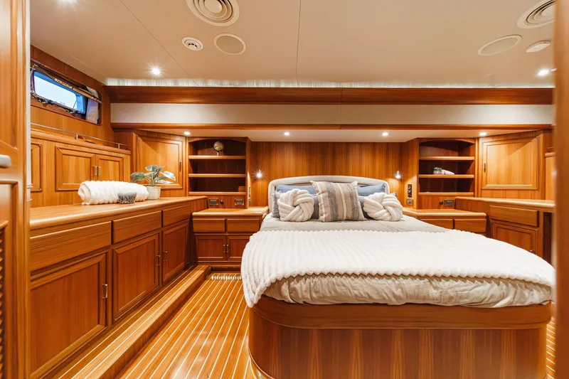 Slide: The Image of Luxurious 2018 Fleming 58 Pilothouse yacht bedroom with elegant wood finish and cozy bedding. - 60