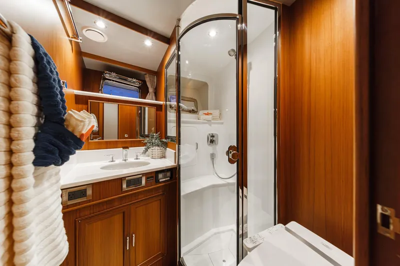 Slide: The Image of Luxurious bathroom in 2018 Fleming 58 Pilothouse yacht with wood accents and modern fixtures. - 63