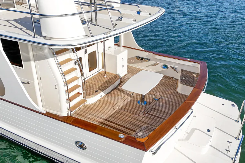 Slide: The Image of 2018 Fleming 58 Pilothouse yacht deck with wooden trim and seating area. - 79