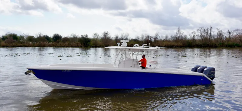 Slide: The Image of 2009 Venture 39 Open boat with blue hull on a calm river. - 1