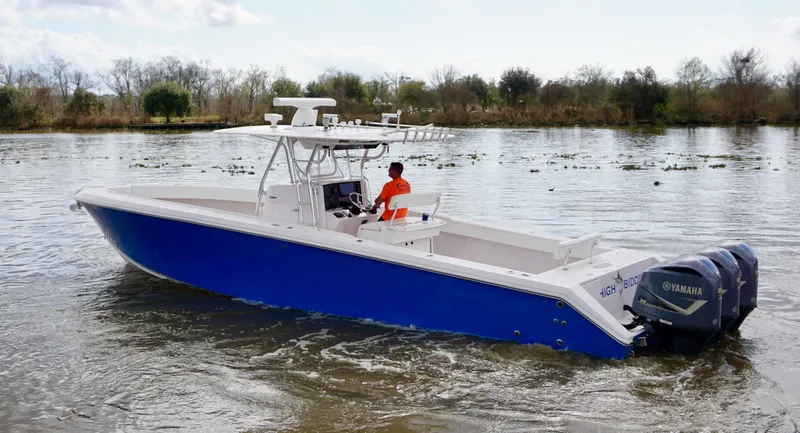Slide: The Image of 2009 Venture 39 Open boat with blue hull on a calm river. - 2