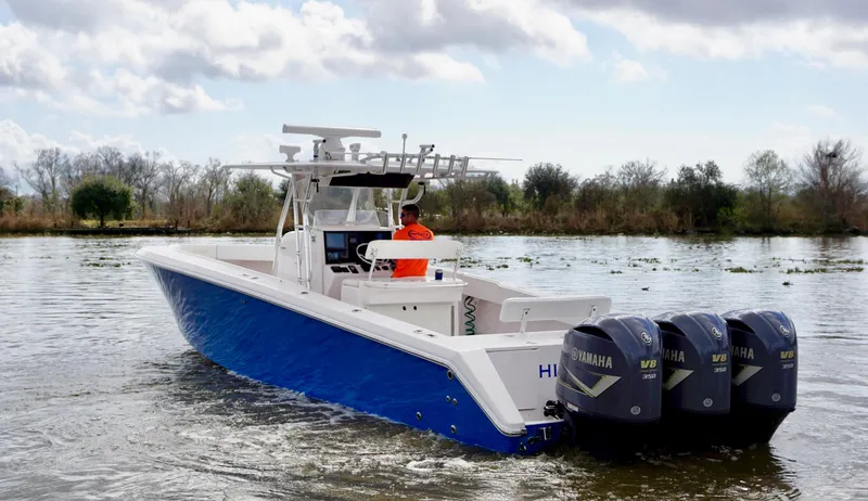 Slide: The Image of 2009 Venture 39 Open boat with triple Yamaha engines on a calm waterway. - 7