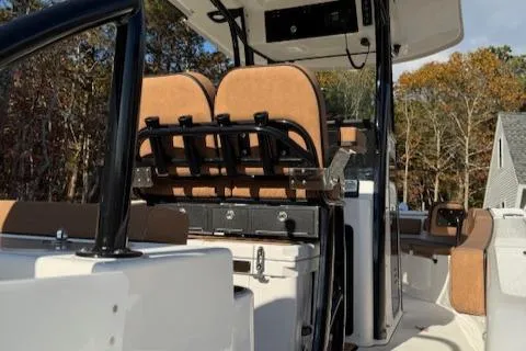 Slide: The Image of 2024 Sea Pro 242 Center Console boat interior with seating and console, surrounded by trees. - 10