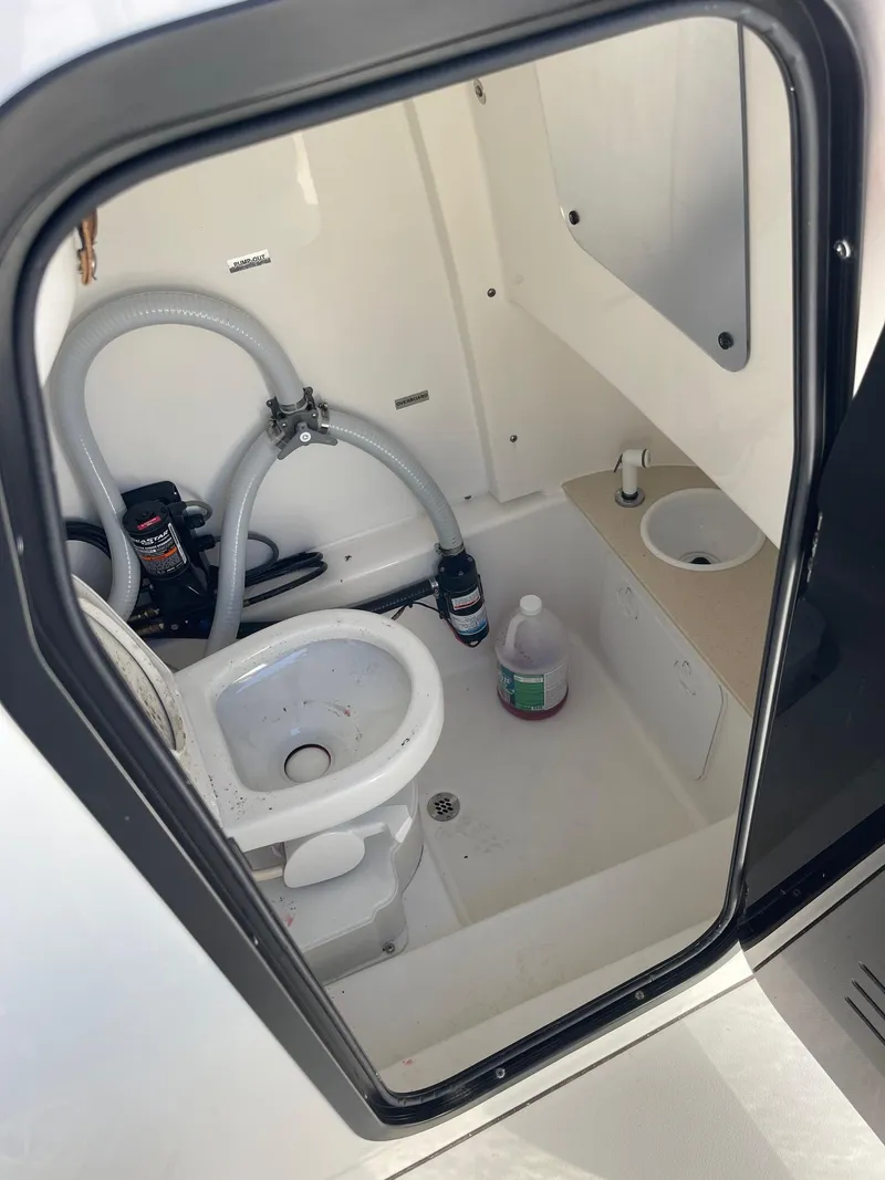 Slide: The Image of 2024 Sea Pro 242 Center Console boat interior with toilet and storage area. - 15