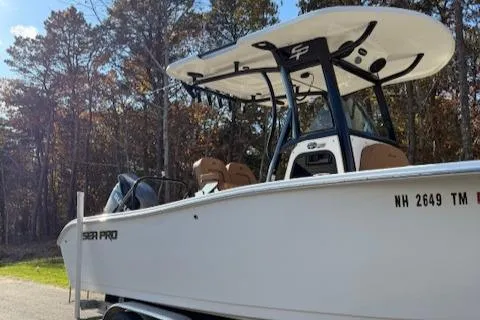 Slide: The Image of 2024 Sea Pro 242 Center Console boat on trailer, surrounded by trees. - 2