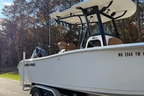 Slide: The Image of 2024 Sea Pro 242 Center Console boat on trailer, parked near trees. - 3