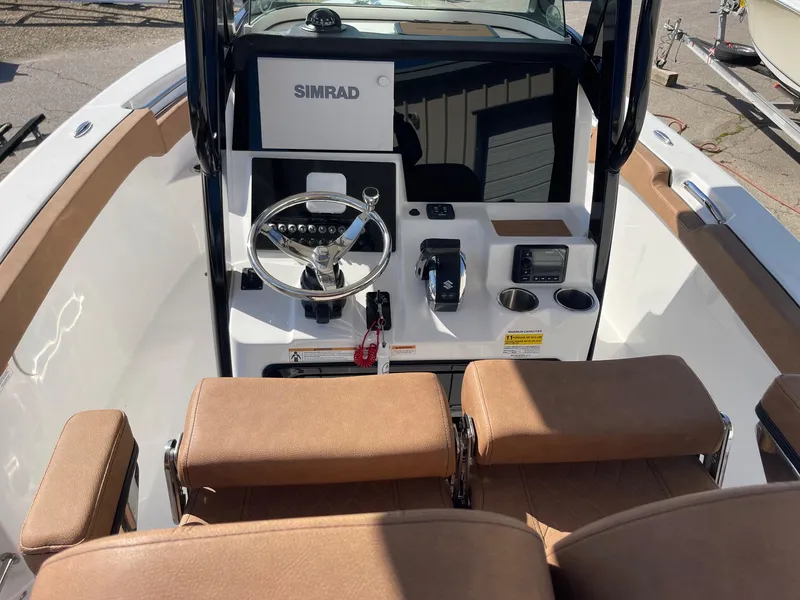 Slide: The Image of 2024 Sea Pro 242 Center Console boat interior with Simrad navigation system and tan seating. - 7