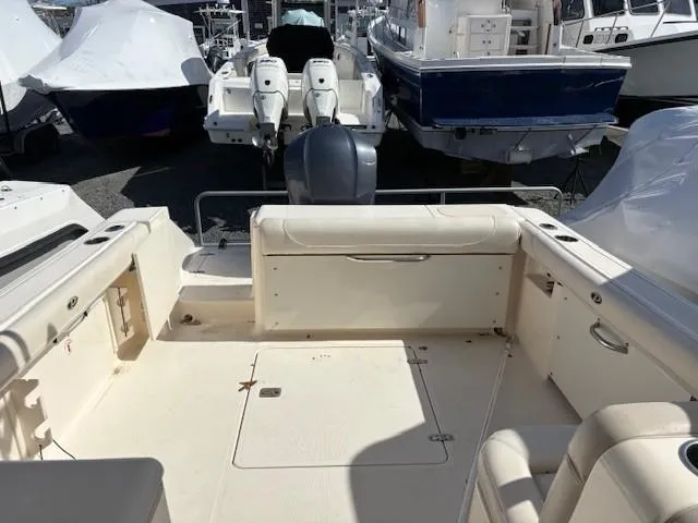 Slide: The Image of 2013 Pursuit 265 Dual Console boat interior with seating and storage compartments. - 10