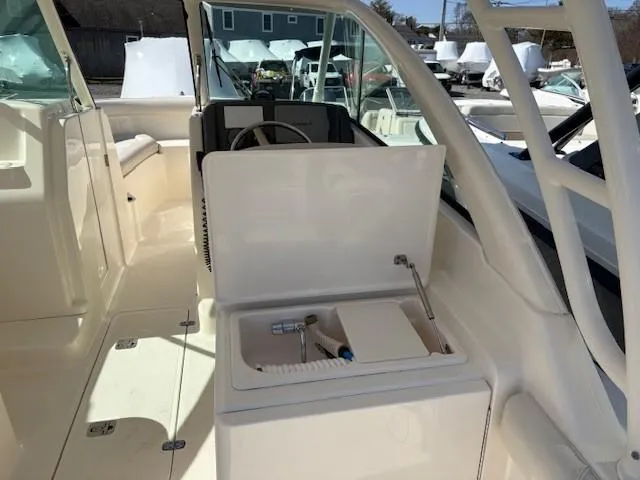 Slide: The Image of 2013 Pursuit 265 Dual Console boat interior with open storage compartment. - 11