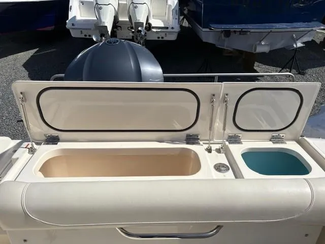 Slide: The Image of 2013 Pursuit 265 Dual Console boat with open storage compartments. - 12