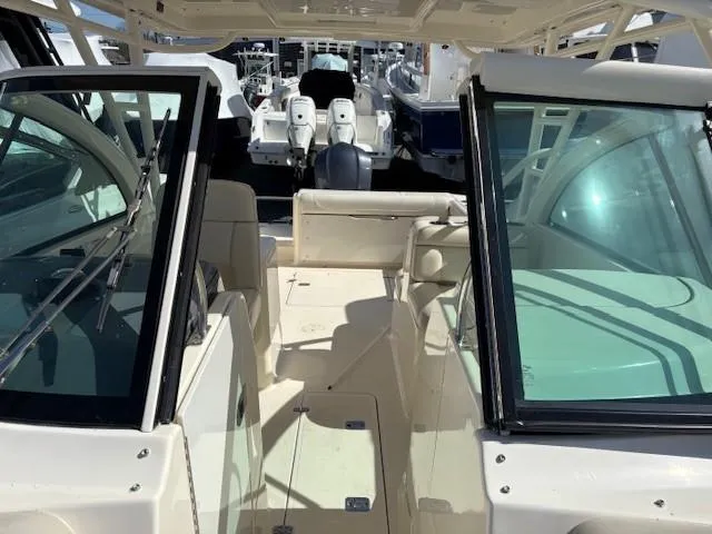 Slide: The Image of 2013 Pursuit 265 Dual Console boat interior with seating and windshield view. - 14