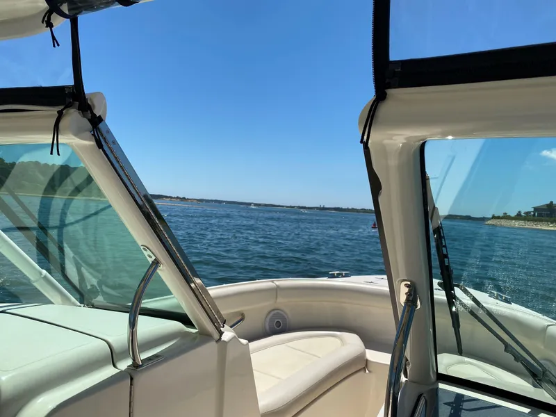 Slide: The Image of 2013 Pursuit D 265 Dual Console boat on open water under clear blue sky. - 5
