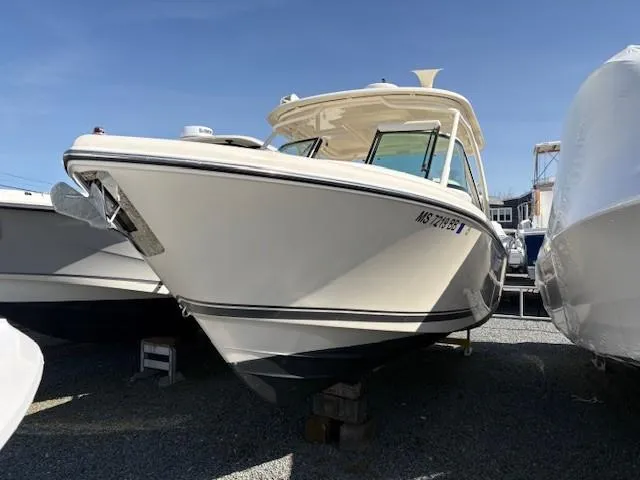 Slide: The Image of 2013 Pursuit 265 Dual Console boat on display in a marina. - 6