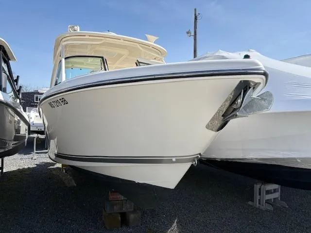 Slide: The Image of 2013 Pursuit 265 Dual Console boat on display in a marina. - 7