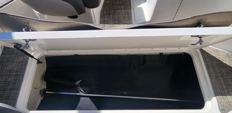 Slide: The Image of 2021 Sea Ray SPX 190 boat storage compartment with open lid, showcasing interior space. - 15