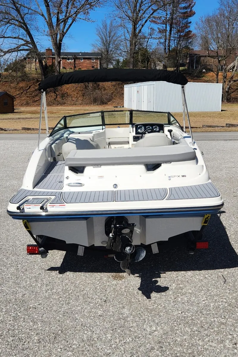 Slide: The Image of 2021 Sea Ray SPX 190 boat, rear view, parked on pavement with trees in background. - 3