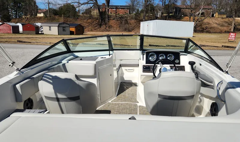 Slide: The Image of 2021 Sea Ray SPX 190 boat interior with seating and dashboard, parked outdoors. - 5