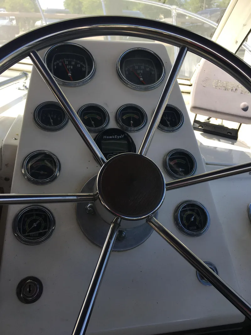 Slide: The Image of Steering wheel and dashboard of a 1976 Bertram 26 Moppie boat. - 11