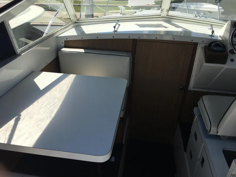Slide: The Image of 1976 Bertram 26 Moppie cabin interior with table and seating. - 13