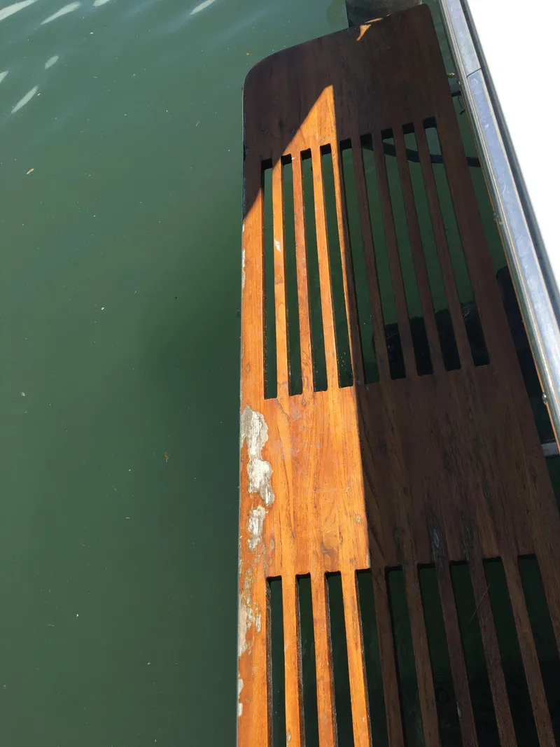 Slide: The Image of Wooden deck of a 1976 Bertram 26 Moppie boat, showing wear and sunlight. - 15