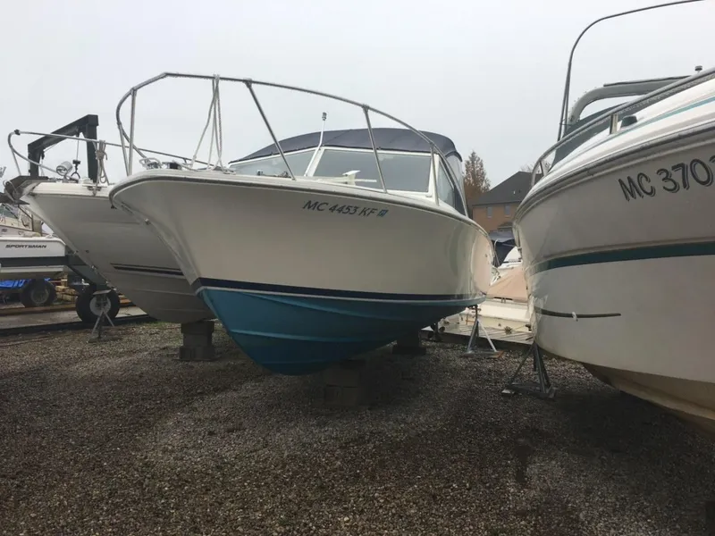 Slide: The Image of 1976 Bertram 26 Moppie boat on dry dock, surrounded by other vessels. - 19