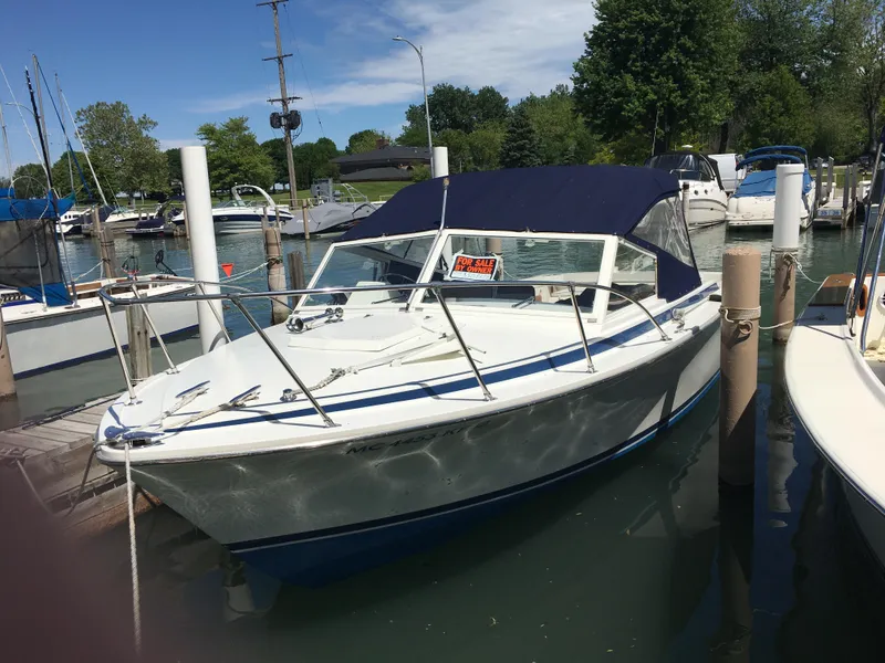 Slide: The Image of 1976 Bertram 26 Moppie boat docked with "For Sale" sign, blue canopy, sunny day. - 20