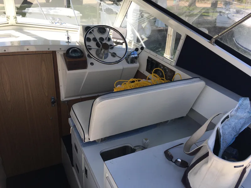 Slide: The Image of Interior of a 1976 Bertram 26 Moppie boat with steering wheel and seating area. - 8