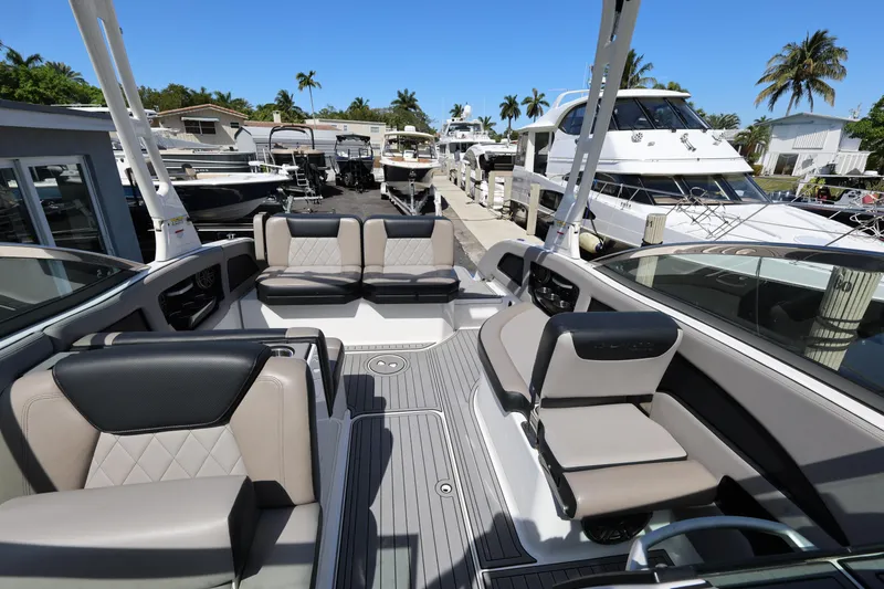 Slide: The Image of 2020 Bryant Calandra 23 boat interior with luxurious seating at a marina. - 25