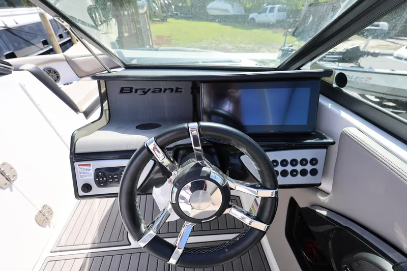 Slide: The Image of Steering wheel and dashboard of 2020 Bryant Calandra 23 boat, featuring modern controls and display. - 27