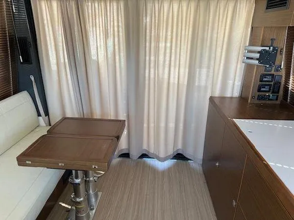 Slide: The Image of Interior of 2023 Bavaria R40 Coupe with wooden table, white seating, and curtains. - 15