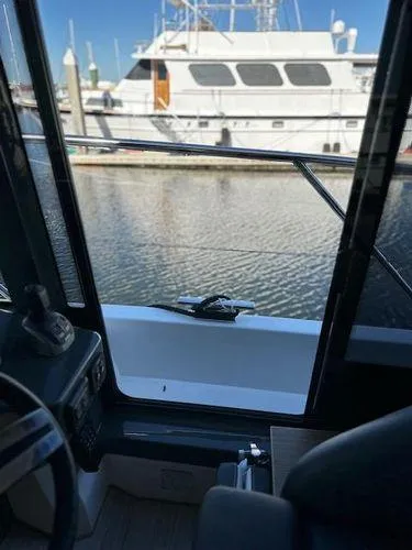 Slide: The Image of 2023 Bavaria R40 Coupe interior view, overlooking marina with docked boats. - 43