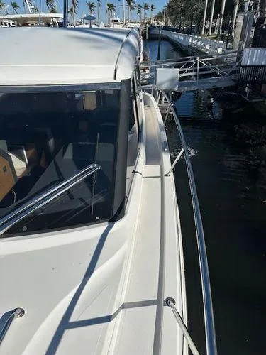 Slide: The Image of 2023 Bavaria R40 Coupe yacht docked at marina, side view with palm trees. - 6