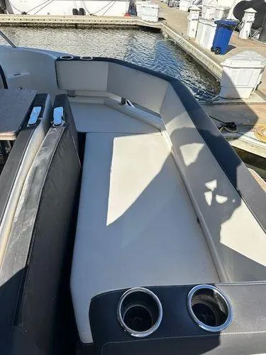 Slide: The Image of 2023 Bavaria R40 Coupe boat interior with seating and cup holders at a marina. - 9